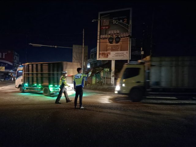 Polisi lalu lintas sedang mengatur arus lau lintas di salah satu persimpangan yang di lalui truk batu bara di Jambi. Foto: Ist